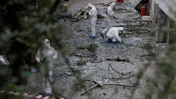 Сотрудники спецслужб на месте взрыва у здания телеканала в Афинах