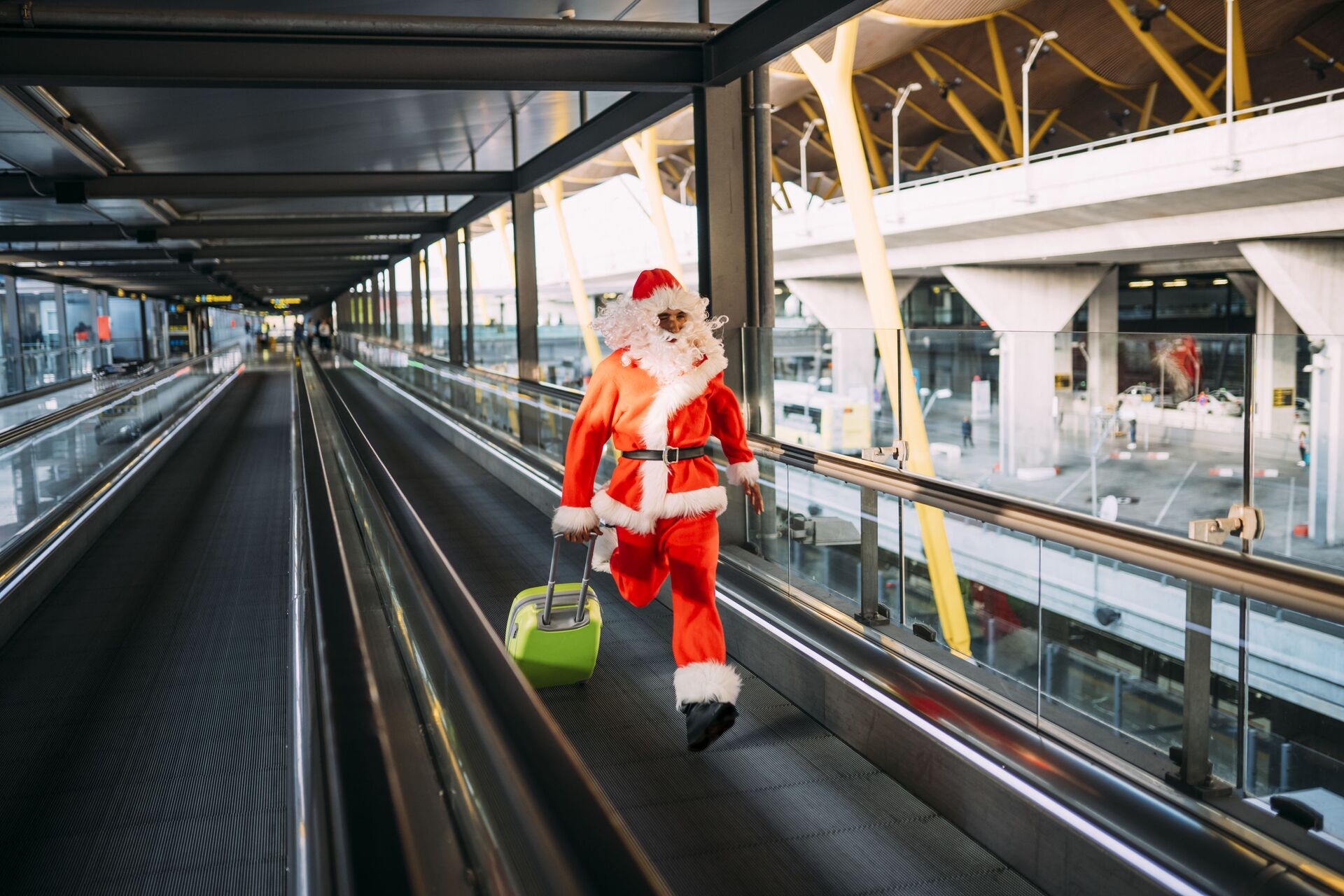 Мужчина в костюме Деда Мороза бежит с чемоданом в аэропорту  - РИА Новости, 1920, 22.12.2020