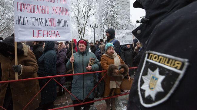 Верующие, протестующие против лишения канонической Украинской православной церкви ее названия, у здания Верховной рады Украины в Киеве