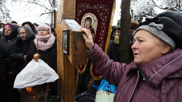 Верующие, протестующие против лишения канонической Украинской православной церкви ее названия, у здания Верховной рады Украины в Киеве