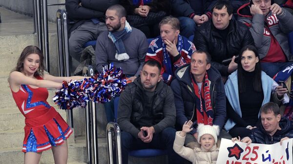 Зрители на трибунах и девушка из группы поддержки во время матча ЦСКА - СКА