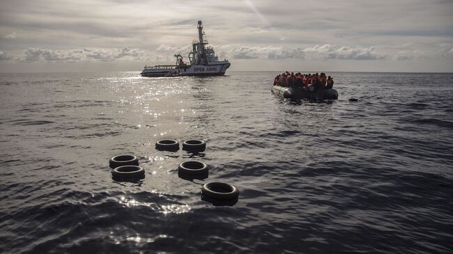 Лодка со спасенными мигрантами направляется к судну Open Arms в Средиземном море. 21 декабря 2018