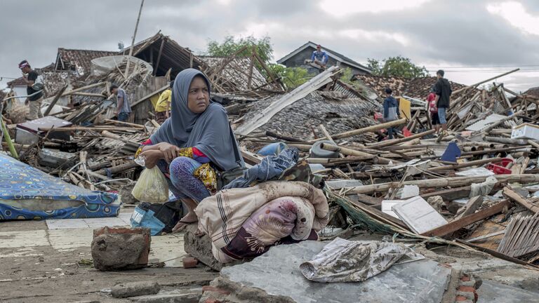Местная жительница у своего дома, разрушенного цунами, в Сумуре, Индонезия. 24 декабря 2018