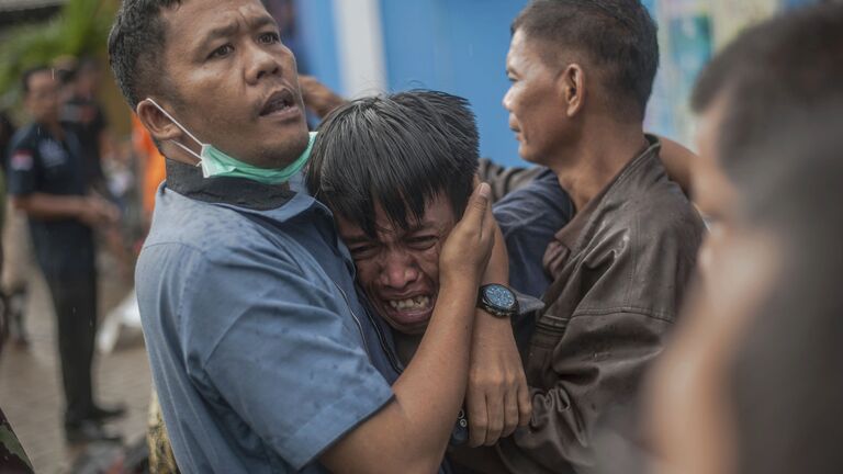 Местные жители после цунами в Индонезии