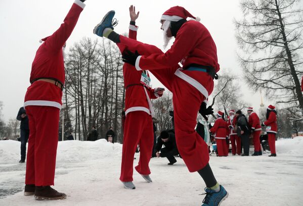 Участники благотворительного забега Дедов Морозов разминаются перед стартом на ВДНХ в Москве