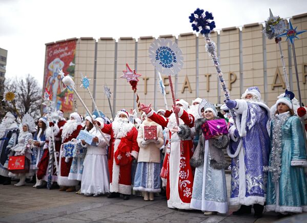 Дед Морозы и Снегурочки во время парада Дедов Морозов и Снегурочек и сказочных персонажей в Краснодаре