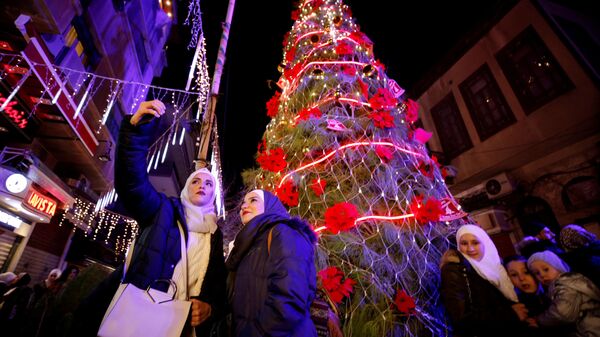 Жители возле рождественской елки в Дамаске