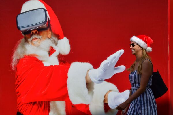 Девушка проходит мимо плаката с изображением Санта-Клауса в Дубаи 