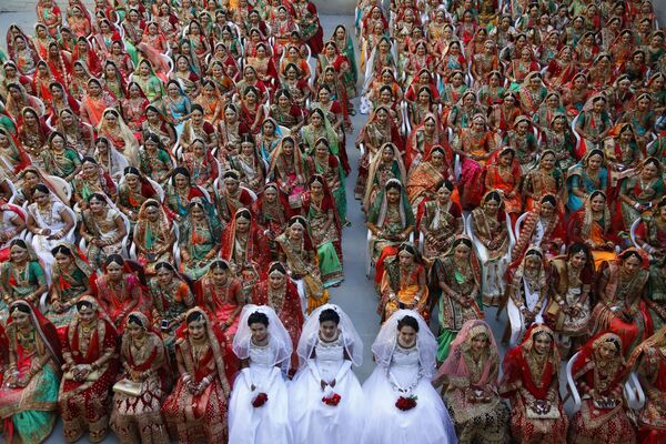 Невесты во время массовой свадьбы в индийском городе Сурат 
