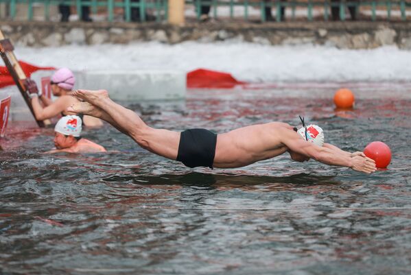 Мужчина во время зимних соревнований по плаванию при температуре минус 21 градуса Цельсия в Шэньяне, провинция Ляонин на северо-востоке Китая