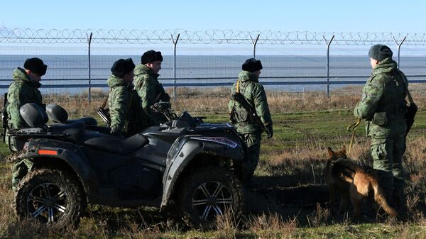 Российские пограничники у заграждения, возведенного в Крыму на границе с Украиной