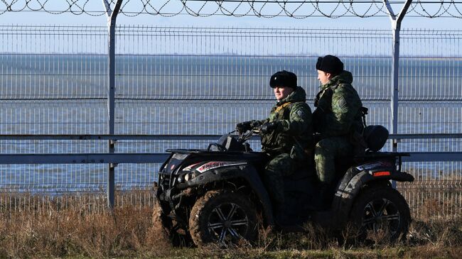 Российские пограничники у заграждения, возведенного в Крыму на границе с Украиной