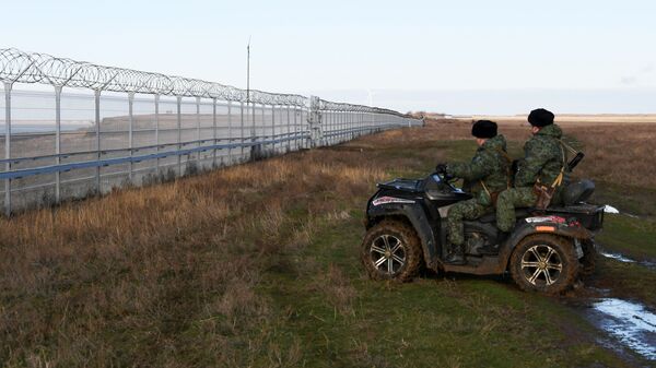 Российские пограничники у заграждения, возведенного в Крыму на границе с Украиной
