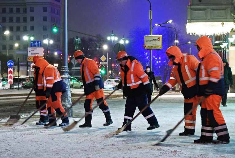 Сотрудники коммунальных служб убирают снег на улице Москвы Сотрудники коммунальных служб убирают снег на улице Москвы