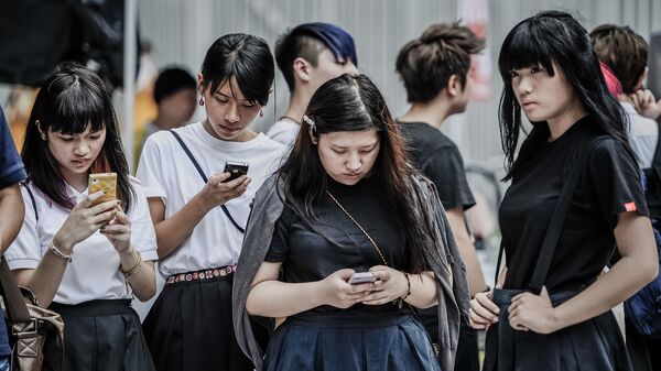 Жители Гонконга проверяют свои мобильные телефоны