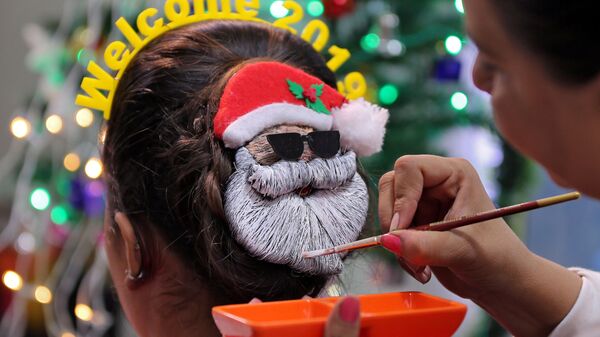 Парикмахер украшает женскую прическу к Новому году 