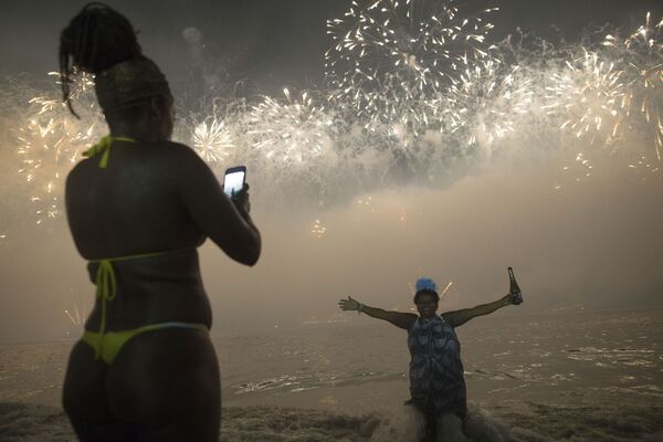 Женщины во время встречи Нового года на пляже Копакабана в Рио-де-Жанейро, Бразилия