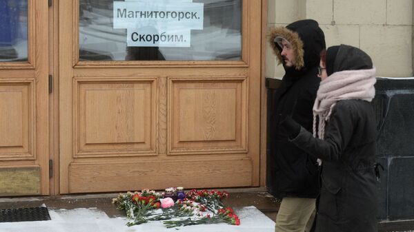 Цветы и свечи возле здания представительства Челябинской области в Москве в память о погибших в Магнитогорске