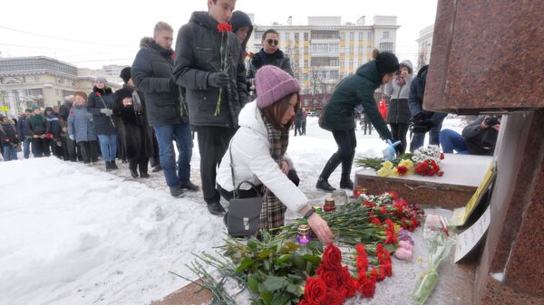 Местные жители возлагают цветы к памятнику Орлёнок в Челябинске на акции памяти по погибшим при обрушении одного из подъездов дома в Магнитогорске. 3 января 2019