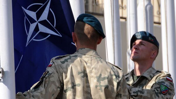 Военнослужащие поднимают флаг НАТО на базе в Афганистане. Архивное фото