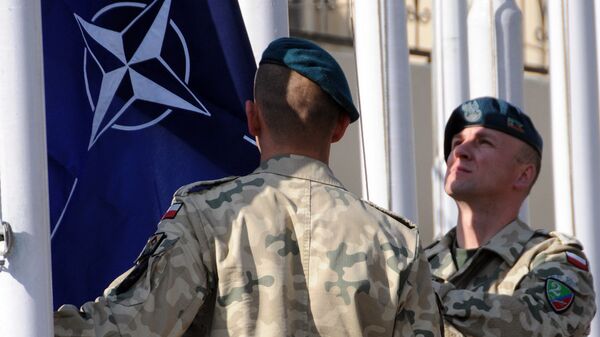 Военнослужащие поднимают флаг НАТО на базе в Афганистане. Архивное фото