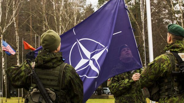 Литовские военнослужащие поднимают флаг НАТО