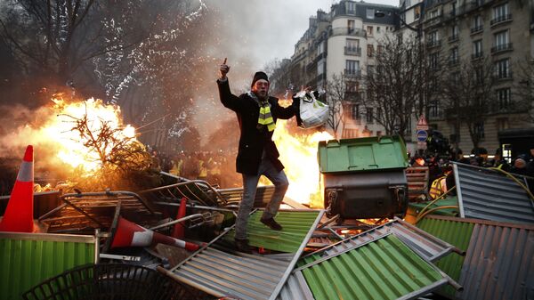 Участник акции желтых жилетов во время протестов во Франции