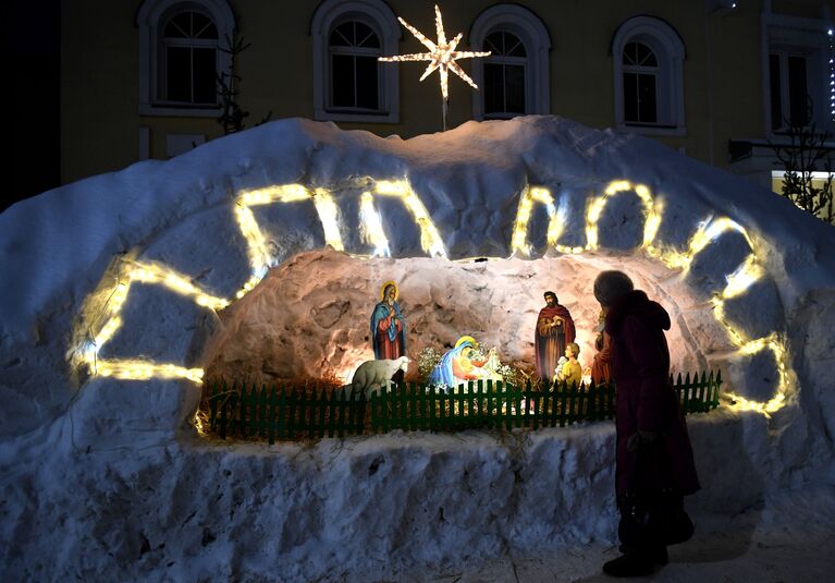 Верующая у вертепа во время рождественского богослужения 