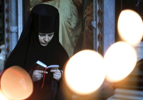 Монахиня перед Рождественским богослужением в храме Христа Спасителя в Москве. 6 января 2018