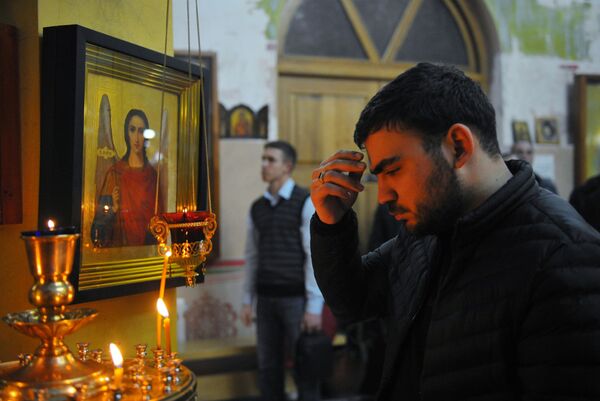 Мужчина в церкви Архангела Михаила в Грозном во время рождественского богослужения