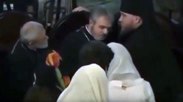Снимок экрана видео, где священник упал в обморок возле президента Украины Петра Порошенко