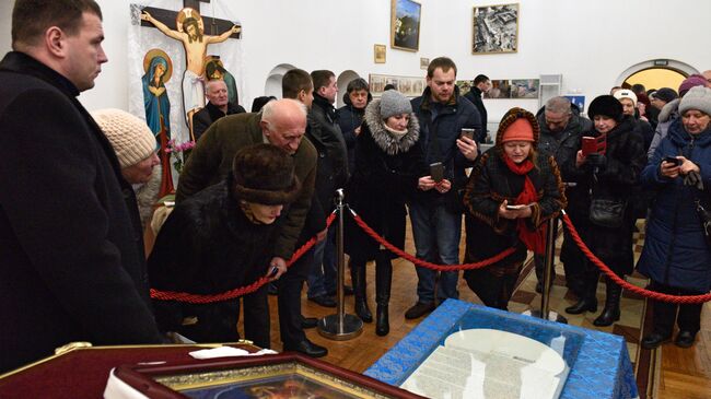 Прихожане фотографируют документ (томос) содержащий решение Священного Синода Вселенского патриархата о предоставлении автокефали УПЦ