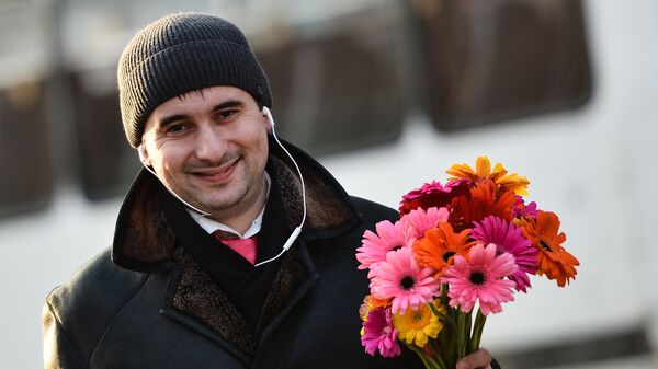 Мужчина с букетом цветов накануне праздника 8 марта в Москве