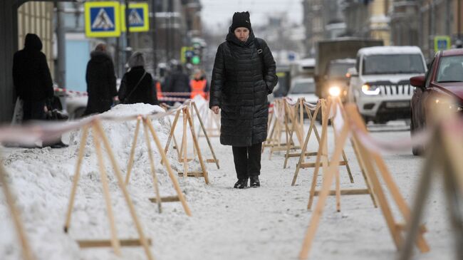 Ограждения на Суворовском проспекте в Санкт-Петербурге, где работники коммунальных служб убирают снег с крыш домов
