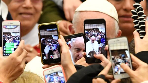 Верующие снимают папу римского Франциска на камеры мобильных телефонов в Ватикане. 9 января 2019