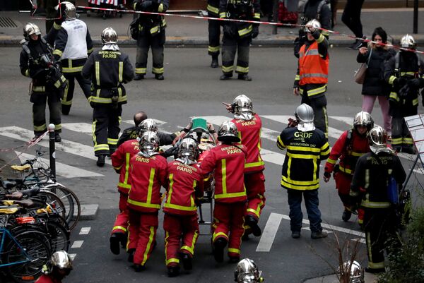 Спасатели с пострадавшим в результате взрыва в пекарне в 9-м округе Парижа, Франция. 12 января 2019