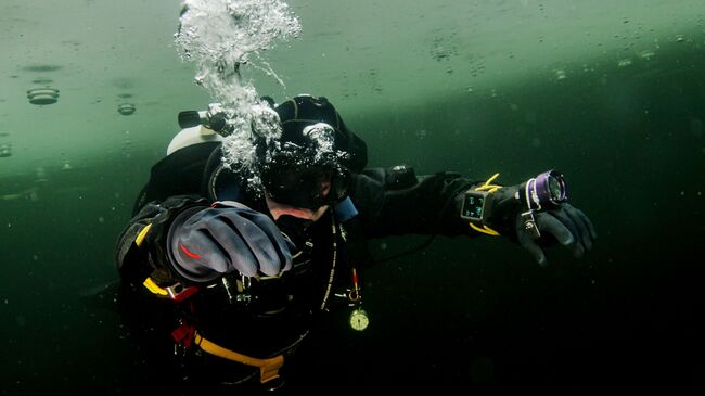 Аквалангист совершает подледные погружения в Амерьевском карьере Щелковского района в дайвинг - центре Пятый Элемент