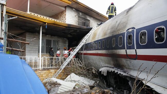 Спасатели на месте крушения транспортного самолета Boeing-707  в городе Карадж в пригороде Тегерана, Иран. 14 января 2019