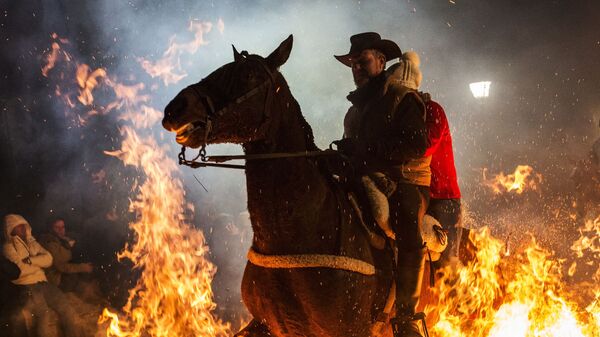 Всадник проезжает через огонь во время ежегодного фестиваля Las Luminarias в испанской деревне Сан-Бартоломе-де-Пинаре