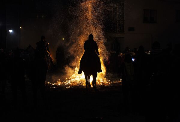 Всадник проезжает через огонь во время ежегодного фестиваля Las Luminarias в испанской деревне Сан-Бартоломе-де-Пинаре