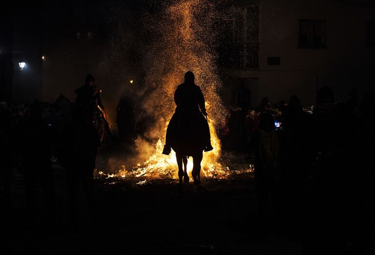 Всадник проезжает через огонь во время ежегодного фестиваля Las Luminarias в испанской деревне Сан-Бартоломе-де-Пинаре