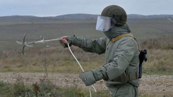 Сапер инженерных войск с кошкой для разминирования взрывных устройств в Грозненском районе Чечнb