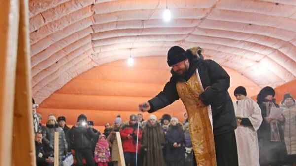 Протоиерей Владимир Севрюков освящает воду в озере Чуоналыр в Мирнинском районе республики Саха (Якутия)