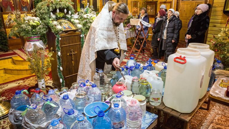 Настоятель храма, иерей Константин Кукушкин совершает чин освящения воды во время крещенской службы в Храме Покрова Пресвятой Богородицы в поселке Пряжа