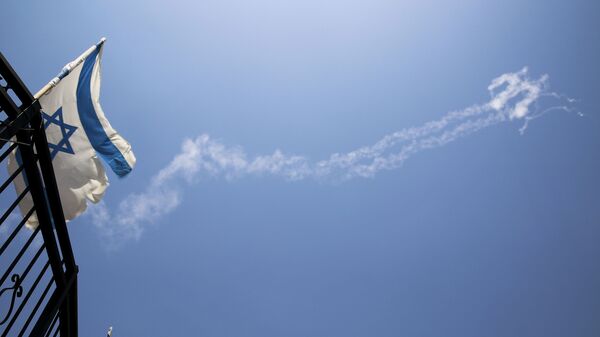 Следы ракет в небе и флаг Израиля