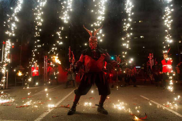 Участник фестиваля Correfoc в костюме демона в Пальма-де-Мальорке, Испания