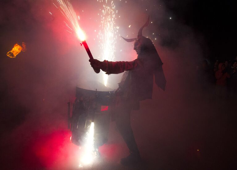 Участник фестиваля Correfoc в костюме демона в Пальма-де-Мальорке, Испания