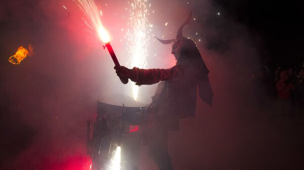 Участник фестиваля Correfoc в костюме демона в Пальма-де-Мальорке, Испания