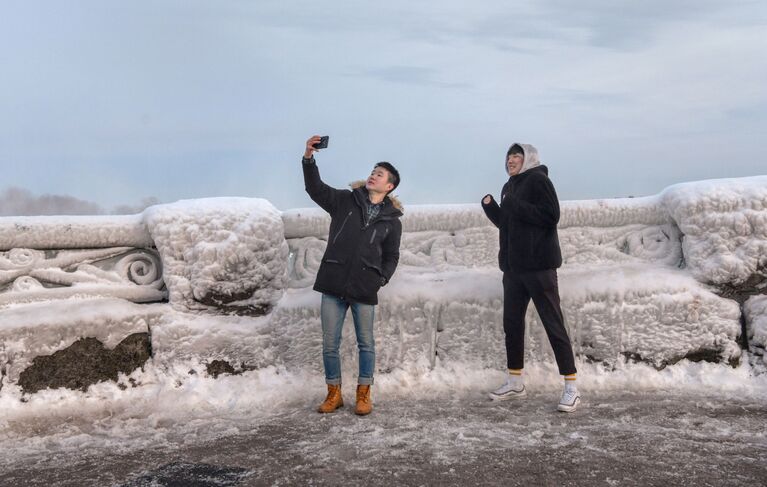 Туристы фотографируются возле Ниагарского водопада