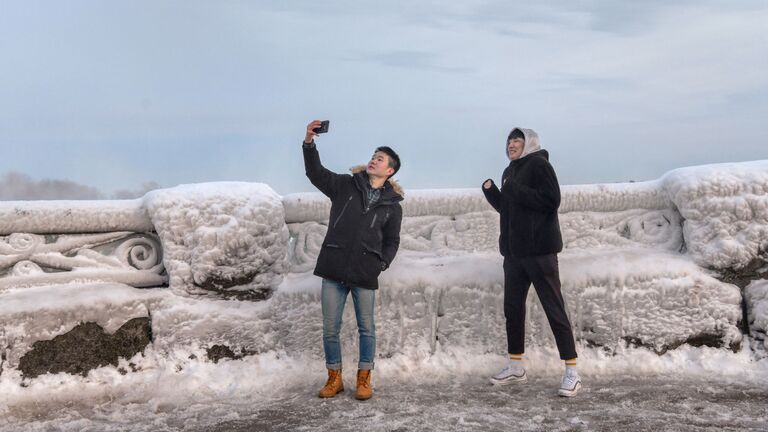 Туристы фотографируются возле Ниагарского водопада